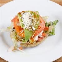 Sope · Handmade corn- based deep dish tortilla topped with meat, beans, sour cream, avocado/guacamo...
