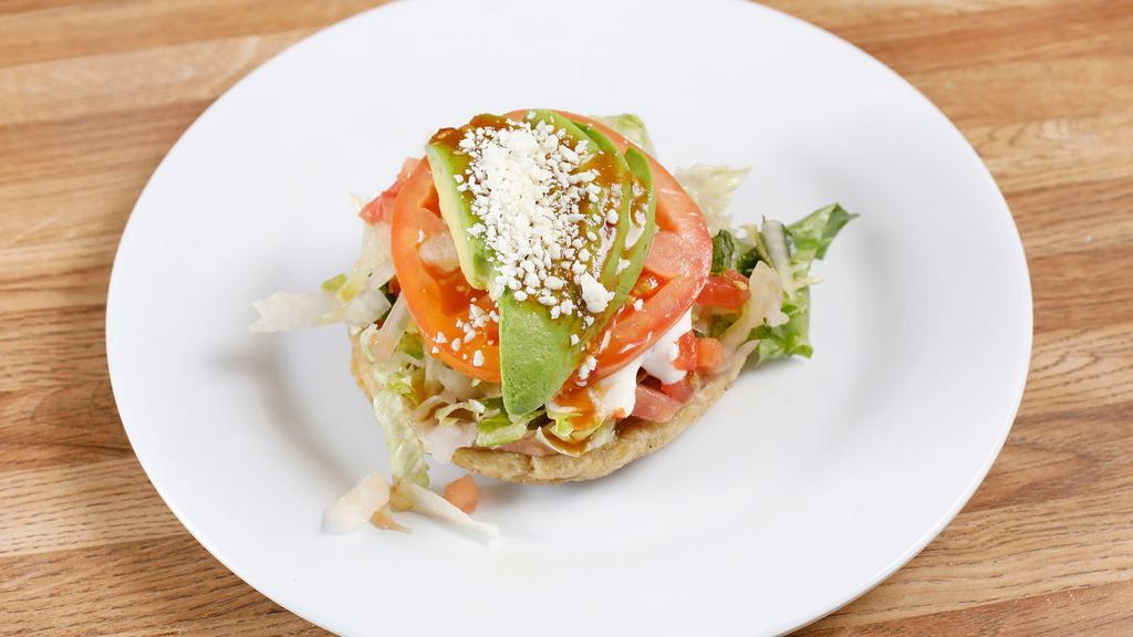 Sope · Handmade corn- based deep dish tortilla topped with meat, beans, sour cream, avocado/guacamole.