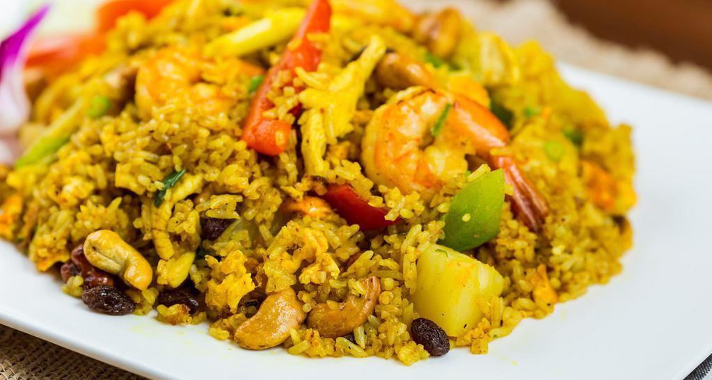 Pineapple Fried Rice · Fried rice with prawns, chicken, pineapple, egg, raisins bell peppers, onions, curry powder, and cashew nuts.  Spicy. Option for gluten-free, can make vegan with fried tofu.