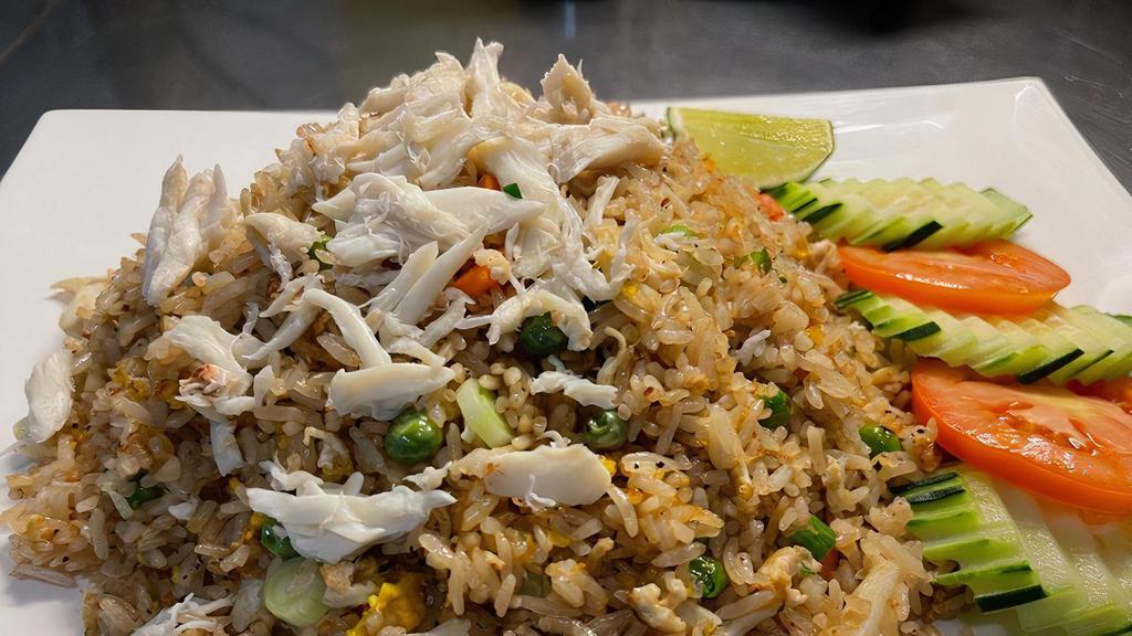 Crab Fried Rice · Pan fried jasmine rice with crab, garlic, egg, peas, carrots, and green onions. Flavorings with gluten free soy sauce and white pepper.