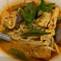 Laksa Mee · Spicy red coconut curry soup with yellow noodles, shredded chicken and mixed vegetables.