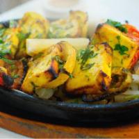 Paneer Tikka Tandoor · Diced paneer marinated in traditional spices. Baked in a special clay oven and served on a s...