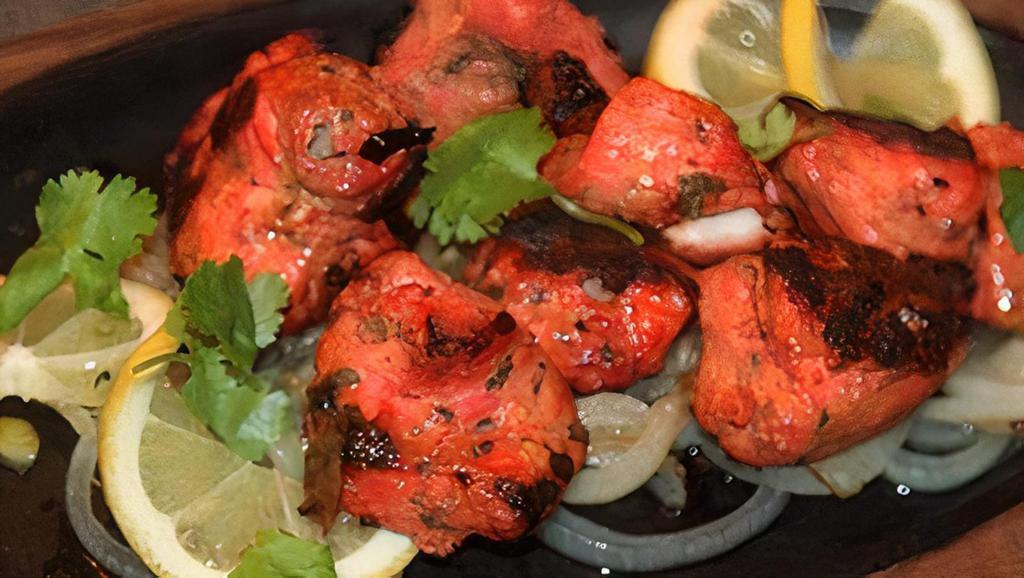 Chicken Tikka Tandoor · Chicken breast marinated in yogurt, ginger garlic, and mild spices. Baked in a special clay oven and served on a sizzler