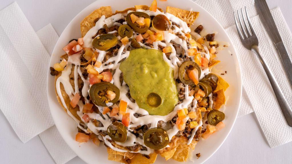 Nachos With Meat · Tortilla chips layered with your choice of meat, beans, cheese, sour cream, tomatoes, jalapeños and guacamole.