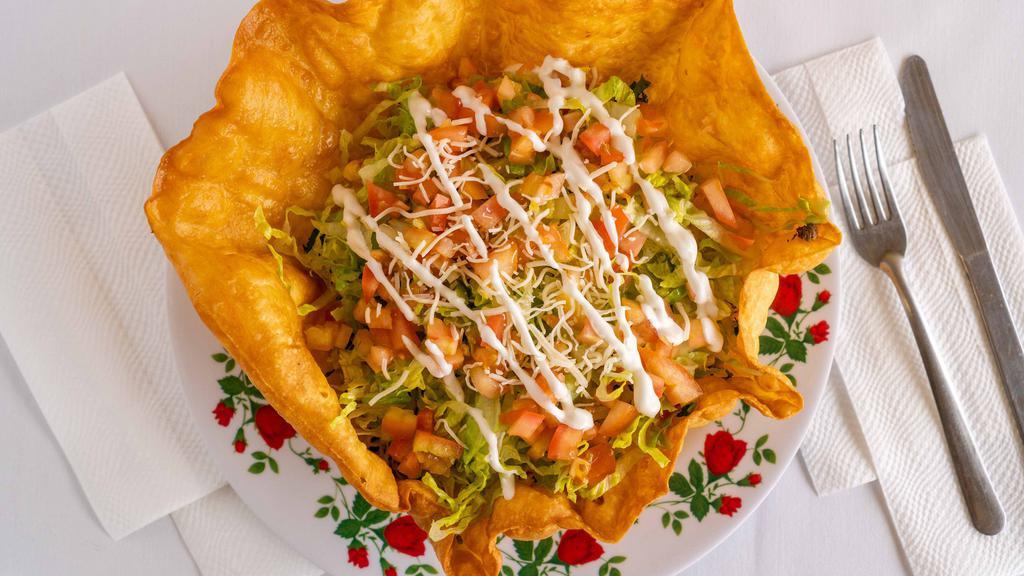 Taco Salad · Fried tortilla shell stuffed with choice of meat, rice, lettuce, cheese, diced tomatoes, sour cream, and guacamole.