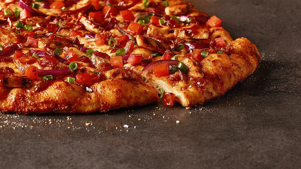 Bbq Chicken Pizza · Backyard BBQ meets handmade pizza grilled white meat chicken, bacon, cheddar, tomatoes, red & green onions, and our sweet & tangy BBQ sauce.