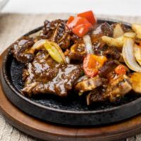 Hot Sizzling Beef Short Ribs · 鐵板牛仔骨 Beef short ribs marinated with onion and scallion.