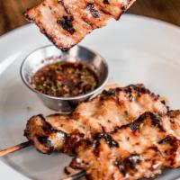 Moo Ping · Grilled marinated pork on skewers served with chili lime sauce.