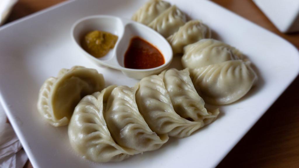 Chicken Momo · Steamed dumpling filled with fresh chicken, ginger, onion, spring onion, and cilantro. Served with tomato sesame chutney.