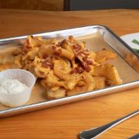 Twisted Town Fries · Our signature curly wedge fries covered in melted cheddar cheese, topped w/bacon bits & gril...