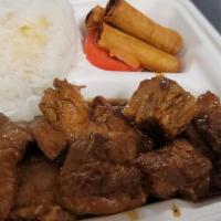 Pork Adobo over Rice · Fatty belly of pork cooked in adobo sauce served with steamed rice and spring rolls.