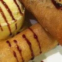 Turon ala Mode · 3pcs of banana fritters on a crispy roll, served with vanilla ice cream and drizzled with ch...