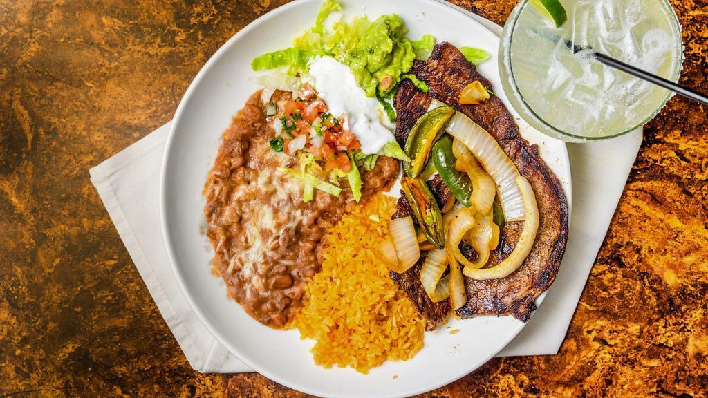 Carne Asada · Grilled thin sliced steak. Served with guacamole and sour cream. Served with rice, refried beans topped with cheese, and a side of tortillas.