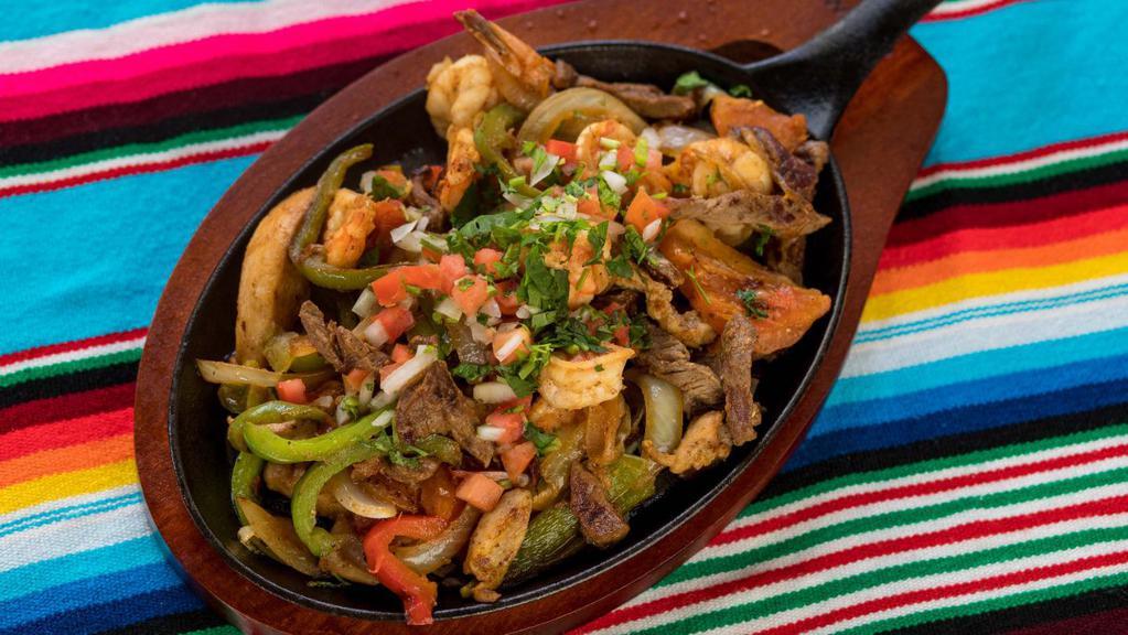 Mixed Fajitas · Chicken, beef, and shrimp. Grilled with tomatoes, bell peppers, and onions served with rice, refried beans, tortillas, sour cream, and guacamole.