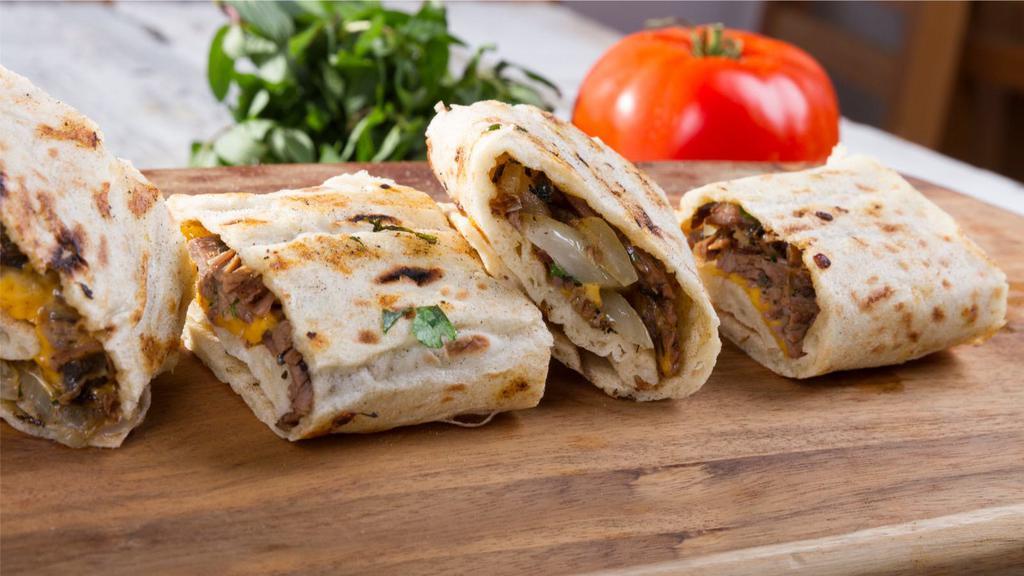 Lamb & Beef Gyro Wrap · Thin sliced lamb and beef, fresh whipped hummus, lettuce, sliced tomatoes, cucumbers, bell peppers, diced onions, and tzatziki sauce.