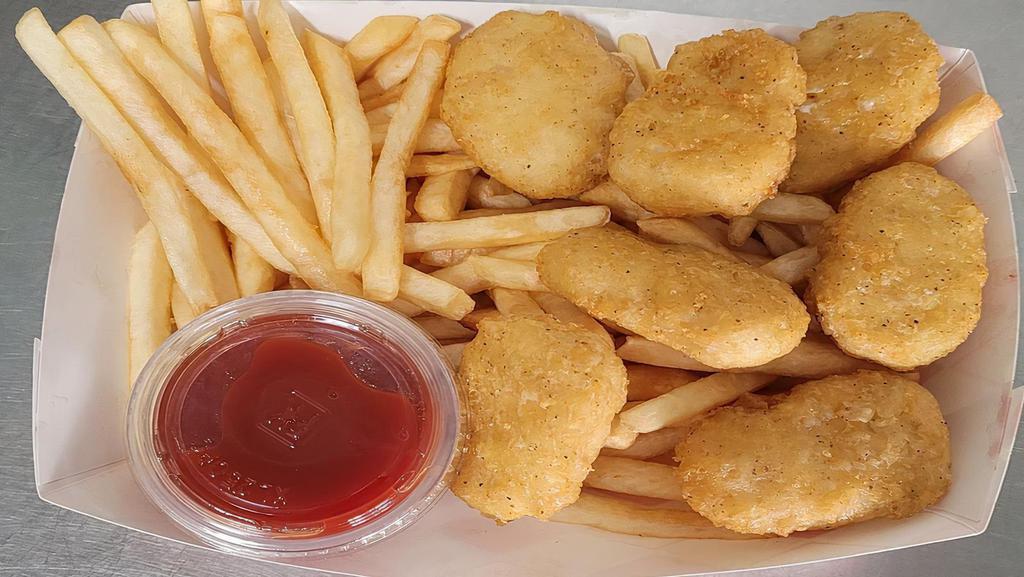 Chicken Nuggets + Fries · Crispy Chicken Nuggets On Top Of French Fries With A Side Of Ketchup