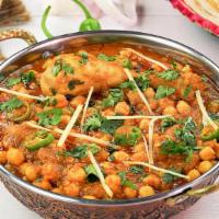 Chicken Cholay · Chicken cooked with garbanzo beans and traditional choley spices.
