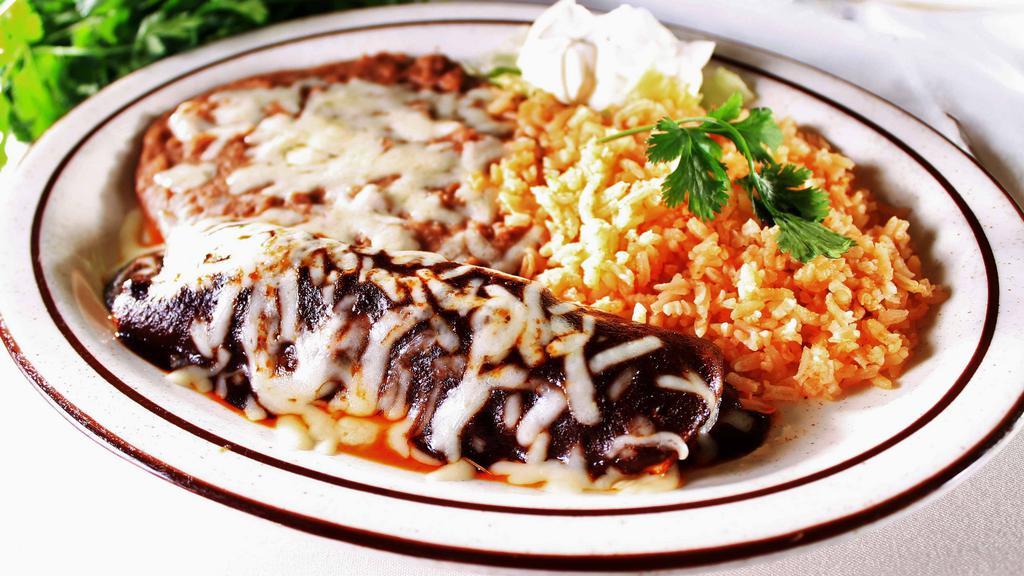 Mole Enchilada · A corn tortilla filled with chicken or cheese in a spicy and  sweet mole sauce, rice, beans and a side of sour cream.