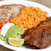 Carne Asada · Served with rice, beans, guacamole, and corn tortillas.