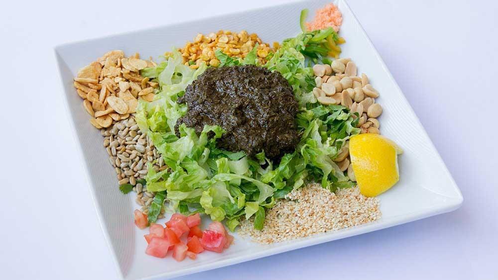 Tea Leaf Salad · This salad is a popular traditional treat unique to Burma. A mix of Burmese tea leaves, fried garlic, yellow beans, peanuts, sesame seeds, sunflower seeds, lettuce, tomato, jalapeño, and dried shrimp. This special salad will awaken your taste buds.