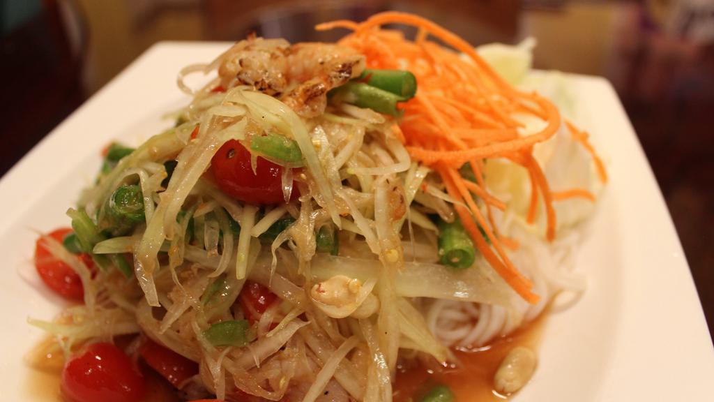Som Tum Goong (Gluten-Free) · Mildly spiced. Shrimp papaya salad. Shredded green papaya salad with tiger prawns, cherry tomatoes, green beans, and garlic. Tossed in chili-lime dressing and topped with peanuts.