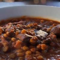 Gheymeh Bademjan · Sauteed beef and split peas cooked together in tomato sauce and topped eggplant served with ...