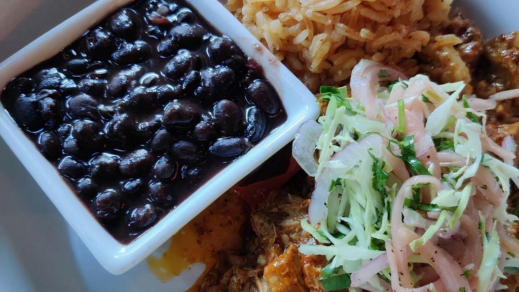 Puerco Pibil  · Anato spiced slow braised pork shoulder, citrus slaw, rice and beans.