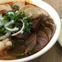 Bún Bò Huế + Giò Heo · Hue's spicy noodle soup + pork knuckle.