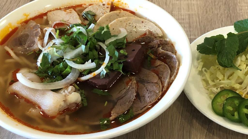 Bún Bò Huế + Giò Heo · Hue's spicy noodle soup + pork knuckle.