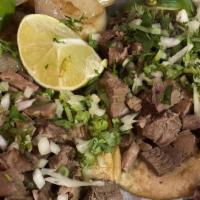 Taco de Lengua (Beef Tongue Taco) · Onions, Cilantro, Grilled 
Onions on the side.