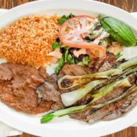 Carne Asada · Steak, grilled onions, rice, beans, salad, sour cream, guacamole.