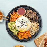 Bussin' Dol Sot Bibimbab · Beef and assorted vegetable with fried egg over rice in sizzling hot stone ware.