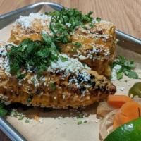 GRILLED ELOTE · One whole ear of Mexican grilled street corn smothered in chipotle aioli, cilantro, and coti...