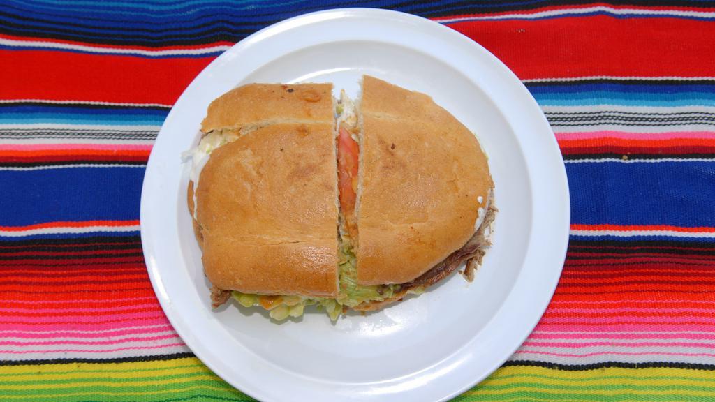 Torta Mexicana · Mexican bread, refried beans, cheese, guacamole, sour cream, lettuce, tomato, jalapeño peppers and meat.