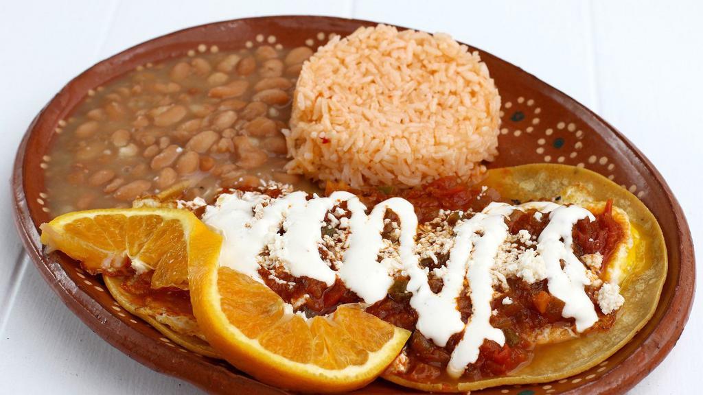 Huevos Rancheros · Two lightly fried corn tortillas with two fried eggs and ranchera sauce. Served with beans.