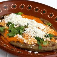Tlacoyito · Handmade blue corn masa cake filled with requezon cheese. Topped with cilantro, onions, crea...