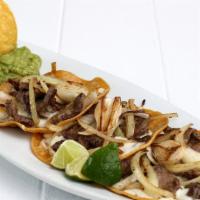 Tacos Tijuana · Three tacos of fried corn tortilla with beef, grilled onions, cheese and guacamole.