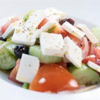 Greek Salad · Topped with cucumbers, tomatoes, red onions, green peppers, feta cheese, and kalamata olives.