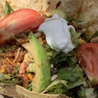 TACO SALAD  Ground Beef · In a crispy tortilla shell with chicken ranchero or shredded beef, lettuce and warmblack be...