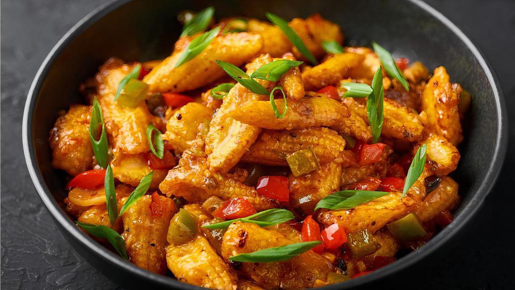 Baby Corn Manchurian · Batter fried baby corn pieces tossed and coated in tangy garlic sauce.