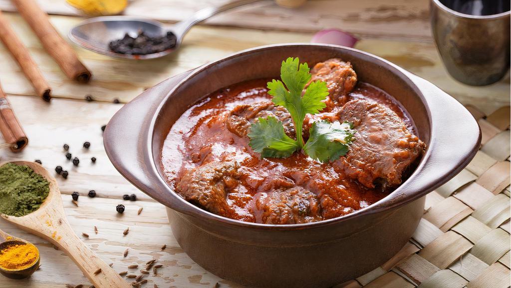 Lamb Rogan Josh · Boneless lamb slow cooked with yogurt, tomatoes, brown onion paste, traditional Indian warm spices and garnished with julienne ginger.