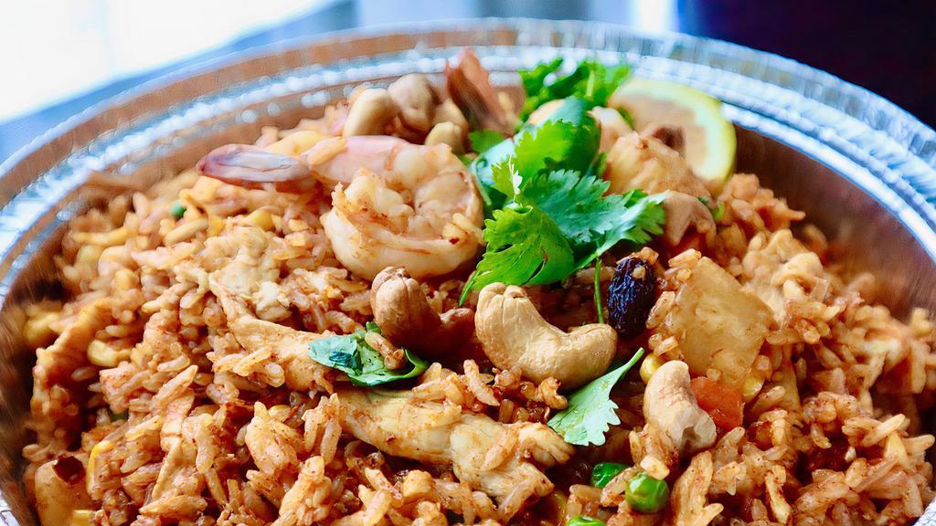 Pineapple Fried Rice · Pan-fried rice with chicken, prawns, pineapple, cashew nuts, carrots, green peas, corns, egg and raisins.