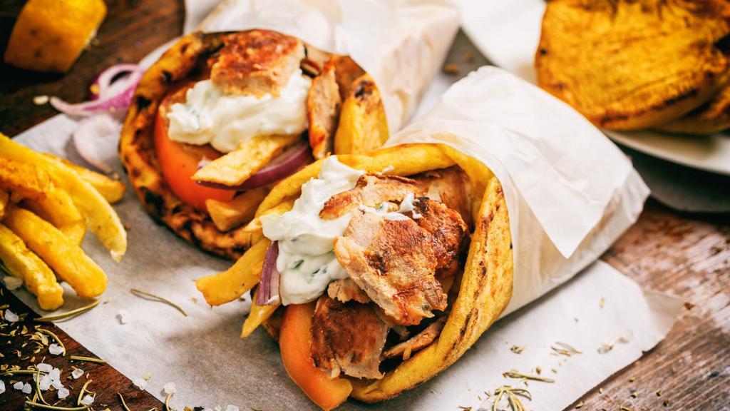 The Chicken Shawarma Wrap · Fresh pita bread filled with sizzling thin slices of chicken shawarma, lettuce, tomatoes, onions, pickles and garlic sauce.