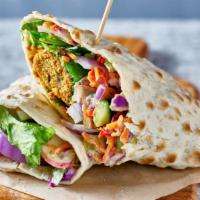 The Falafel Wrap · Crispy chickpeas wrapped in pita bread with lettuce, tomatoes, onions, parsley, pickles, cuc...