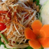 A03. Papaya Salad · Shredded green papaya with tomatoes, green bean, ground peanut, dry shrimps in spicy lime dr...