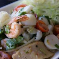A01. Spicy Seafood Salad · Shrimps, calamari, fish balls, scallops, white fungus and sliced fish cakes with tomatoes, o...