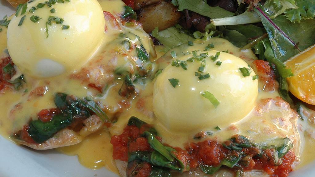 L'accademia Poached Eggs · Two poached eggs with spinach, tomato and Hollandaise sauce on English muffins, served with home-fried potatoes.