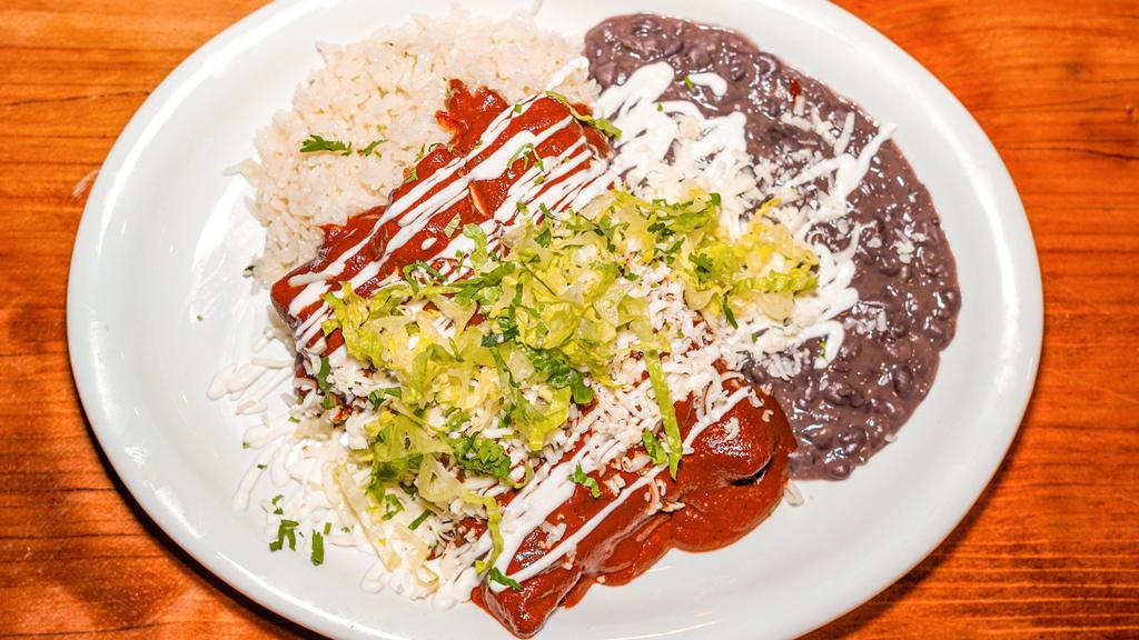Enchiladas de Mole Poblano (2pcs) · Two enchiladas filled with melted cheese, and choice of chicken, carnitas or cheese only, topped with mole poblano, lettuce, sour cream, queso fresco and pickled onions. Served with Spanish rice and choice of beans