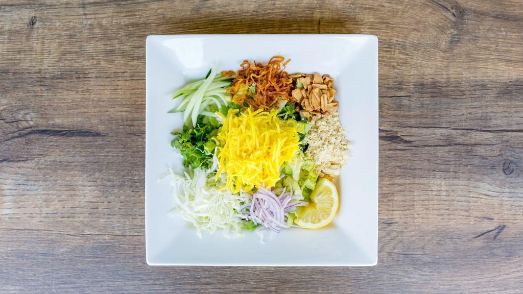 Mango Salad · Gluten free. Shredded green mangoes served with fried onions, fried garlic, cabbage, red onions, yellow bean powder, cucumber, cilantro.