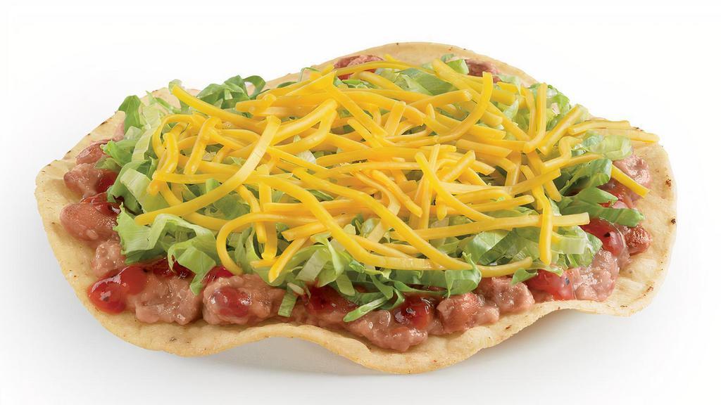 Crunchtada® Tostada · The original Crunchtada®! A thick, wavy, crunchy corn shell layered with slow-cooked beans made from scratch, signature tangy Salsa Casera, crisp shredded lettuce, and freshly grated cheddar cheese.